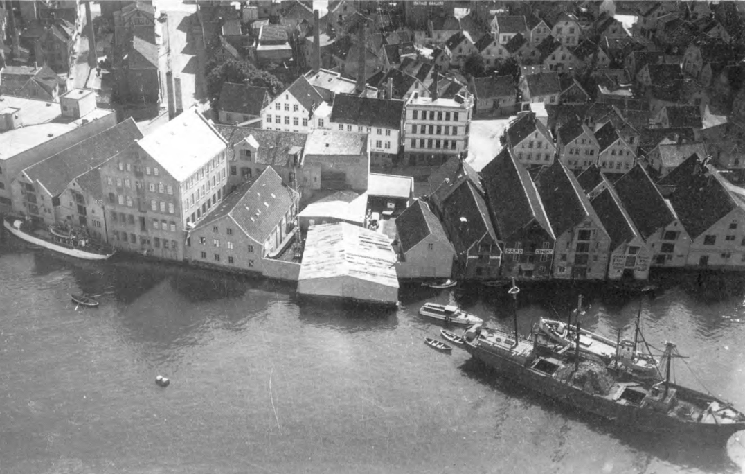 Historisk flyfoto av sjøhusrekken ved Fiskepiren med skip og brygger